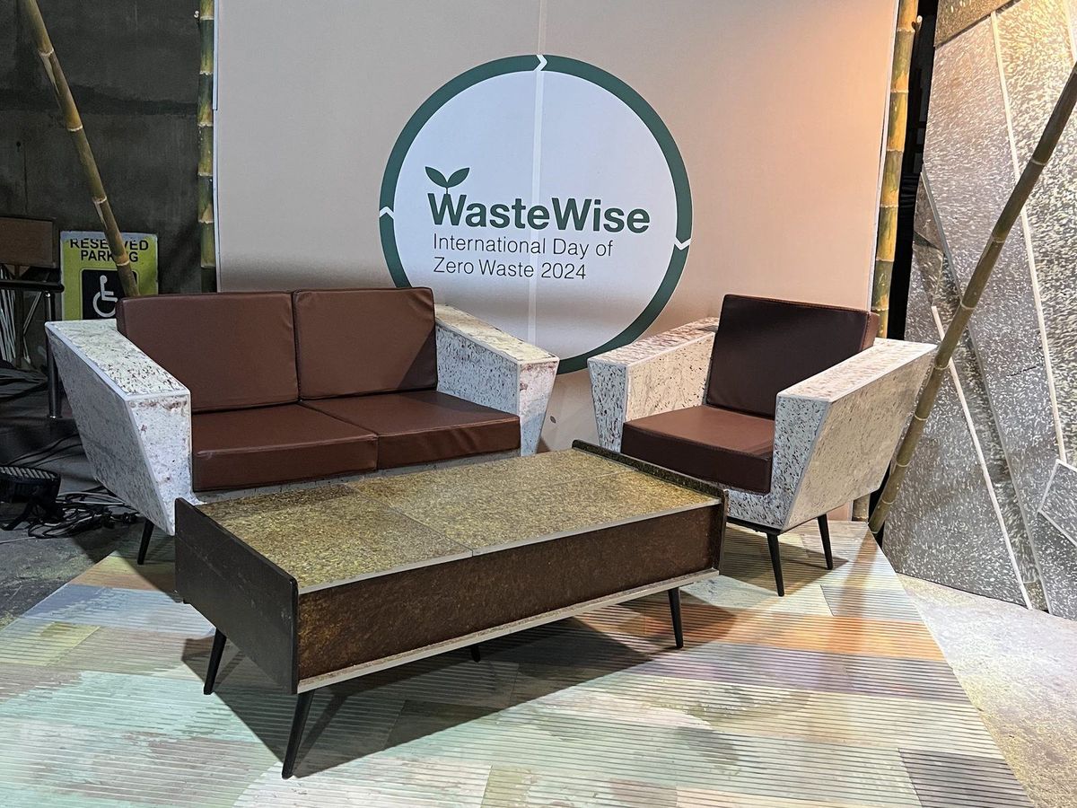 A sofa, armchairs and a coffee table made from speckled composite board, set on a WasteWise exhibition stand.