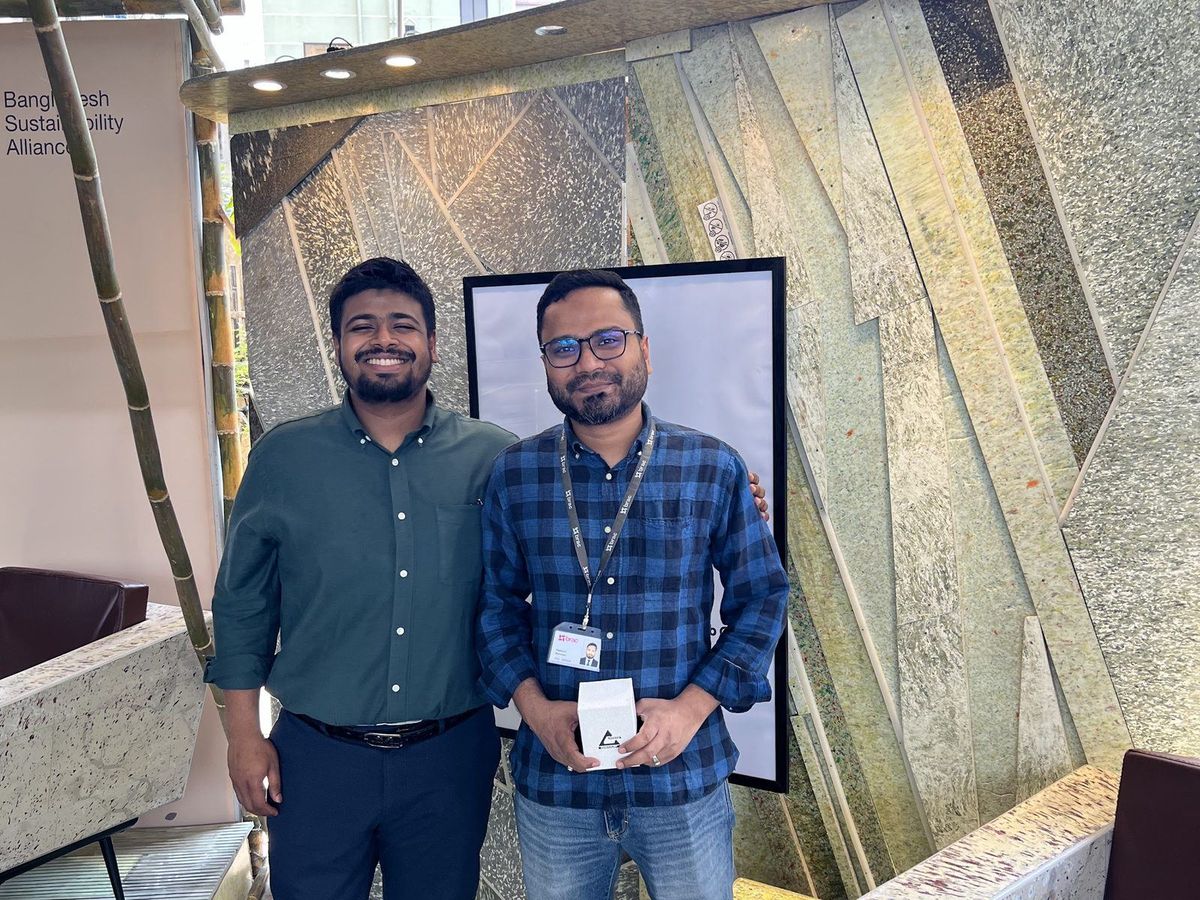 Two RePro team members standing in front of a patterned board wall at the WasteWise exhibition stand.